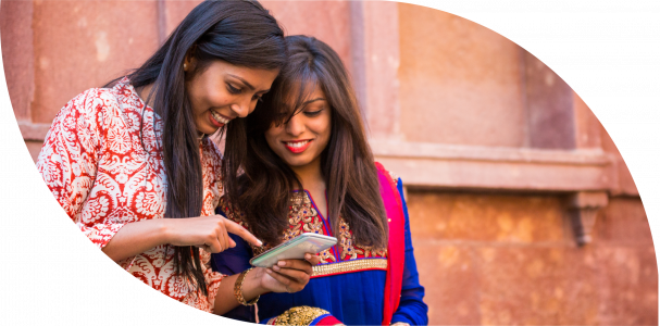 Two women are looking at a mobile phone.