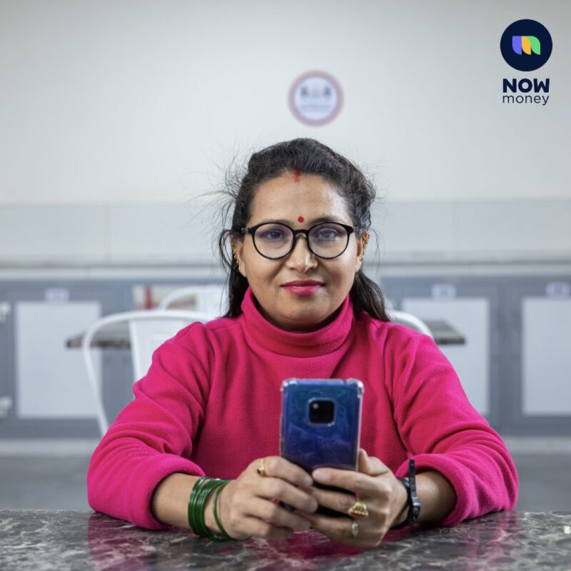 A headshot of a female worker. She holds her mobile phone in her hands.