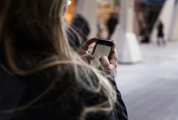 A woman on her smartphone considering to send money from the UAE