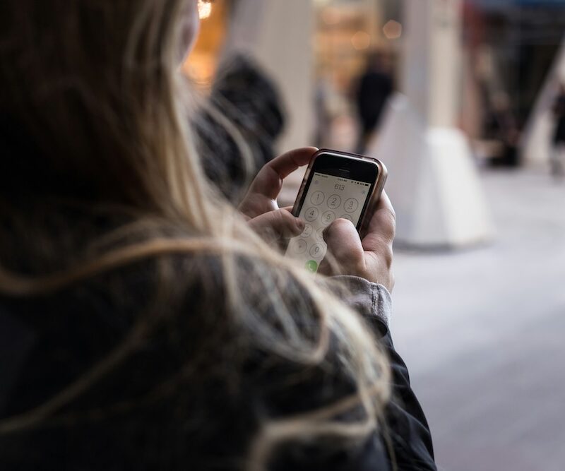 A woman on her smartphone considering to send money from the UAE